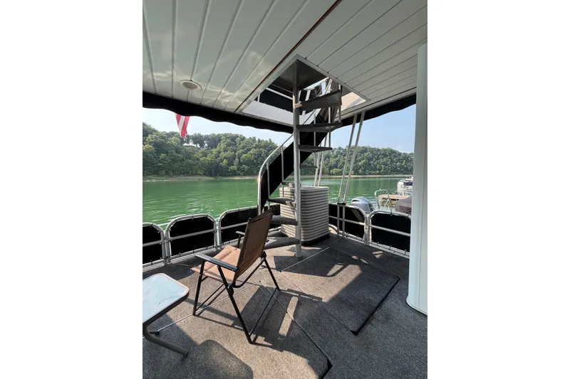Slide: The Image of Lakeview boat deck with chairs, stairs, and scenic lake view. - 37