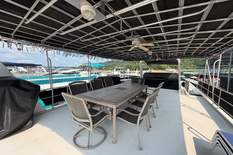 Slide: The Image of Covered deck on Lakeview boat with dining table and chairs, docked at marina. - 45