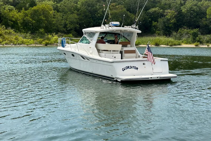 Slide: The Image of 2002 Tiara Yachts 3500 Open cruising on a serene lake with lush greenery. - 48