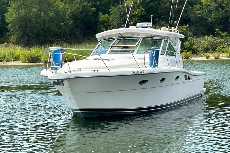 Slide: The Image of 2002 Tiara Yachts 3500 Open cruising on a serene lake with lush greenery. - 7
