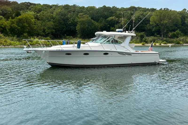 Slide: The Image of 2002 Tiara Yachts 3500 Open cruising on a serene lake with lush green surroundings. - 9