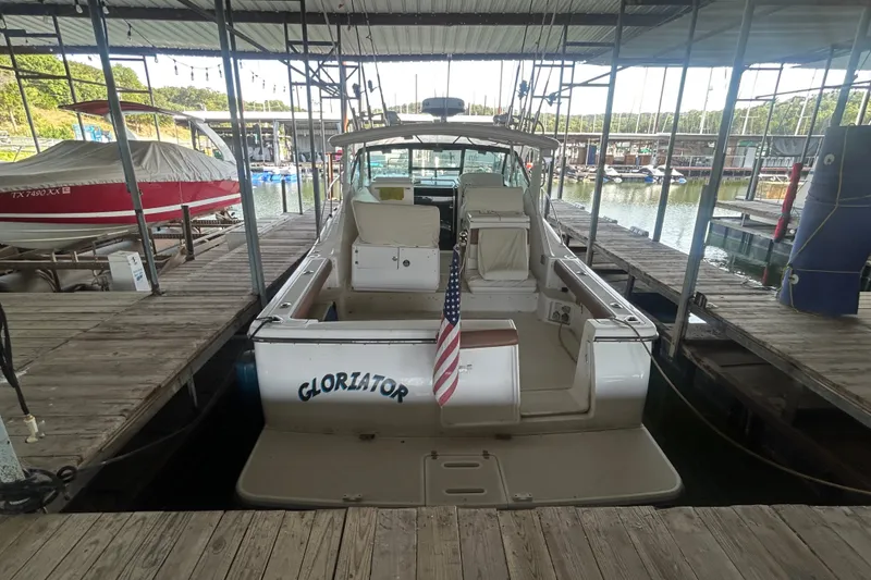 Slide: The Image of 2002 Tiara Yachts 3500 Open docked, featuring spacious deck and American flag. - 17