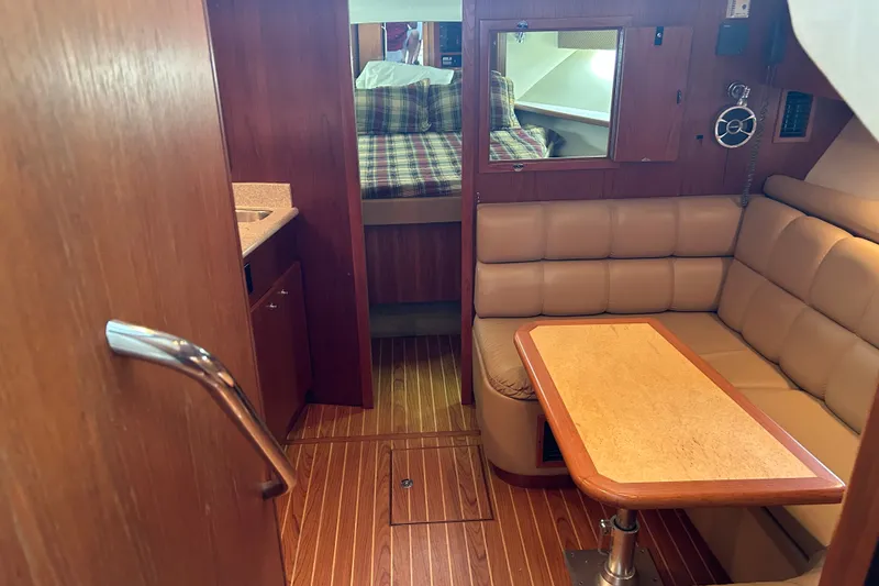 Slide: The Image of Interior of 2002 Tiara Yachts 3500 Open with cozy seating and wooden finishes. - 27