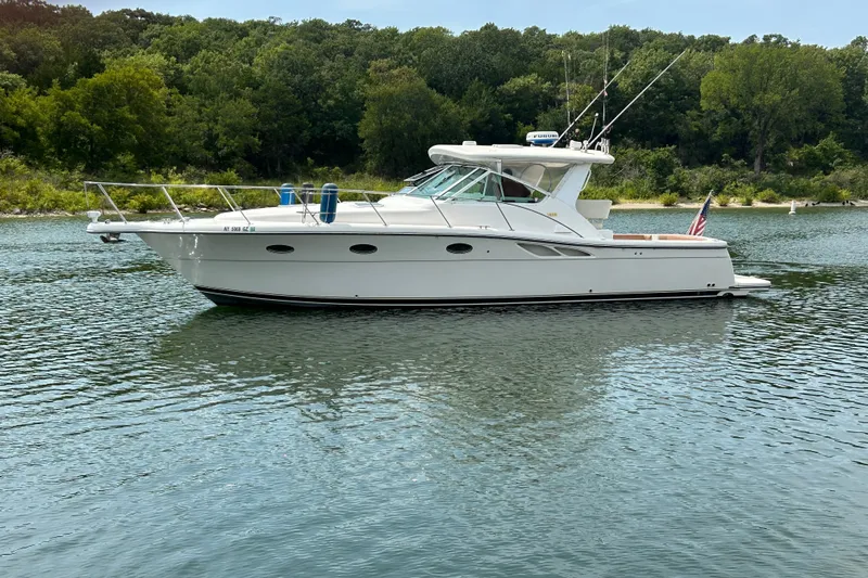 Slide: The Image of 2002 Tiara Yachts 3500 Open boat on a serene lake with lush green background. - 12