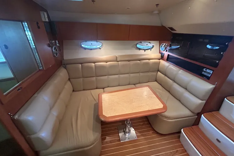 Slide: The Image of Luxurious interior of 2002 Tiara Yachts 3500 Open with leather seating and wooden table. - 28