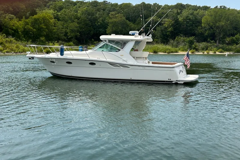Slide: The Image of 2002 Tiara Yachts 3500 Open boat on calm water with lush green shoreline. - 6