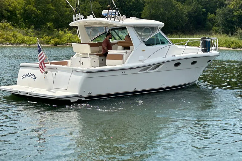 Slide: The Image of 2002 Tiara Yachts 3500 Open cruising on a serene lake with lush greenery. - 11