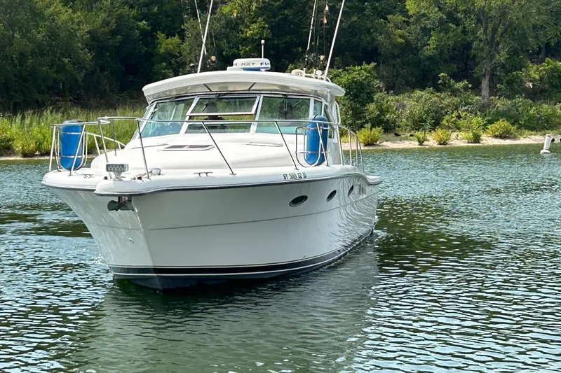 Slide: The Image of 2002 Tiara Yachts 3500 Open boat on calm water, surrounded by lush greenery. - 2