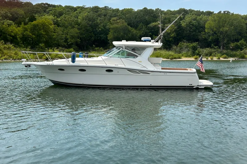 Slide: The Image of 2002 Tiara Yachts 3500 Open boat on a serene lake with lush green shoreline. - 47