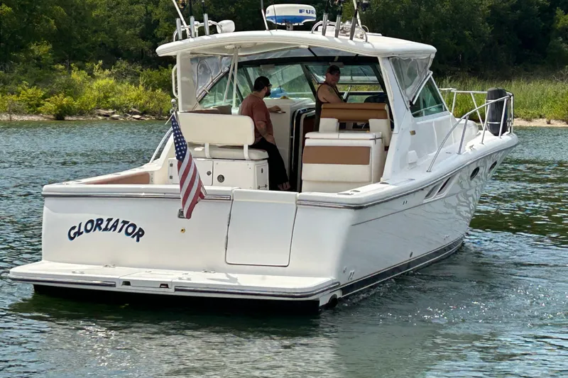 Slide: The Image of 2002 Tiara Yachts 3500 Open boat named "Gloriator" on a serene lake. - 10
