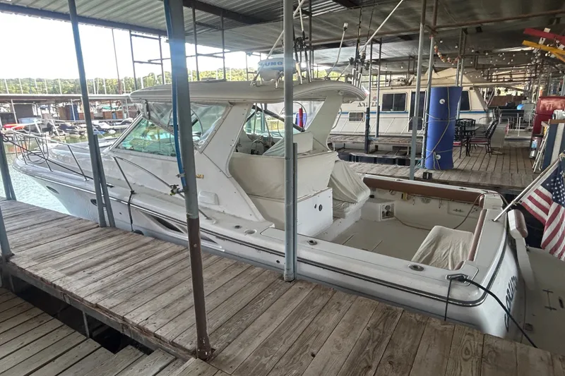 Slide: The Image of 2002 Tiara Yachts 3500 Open docked in a marina, showcasing sleek design and spacious deck. - 13