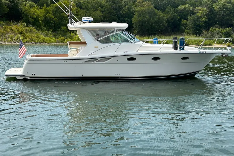 The Image of 2002 Tiara Yachts 3500 Open cruising on a serene lake with lush green backdrop. - 0