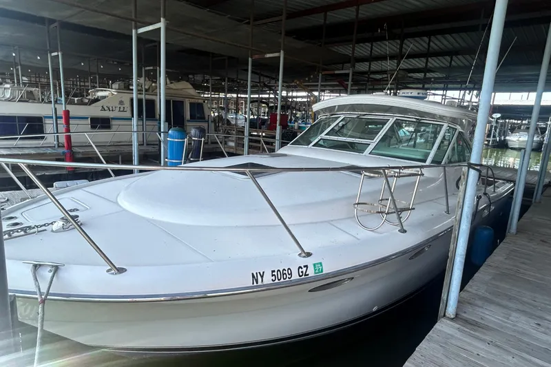 Slide: The Image of 2002 Tiara Yachts 3500 Open docked in a marina, showcasing sleek design and spacious deck. - 18