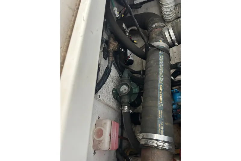 Slide: The Image of Engine compartment of a 2002 Tiara Yachts 3500 Open, featuring hoses and mechanical components. - 43