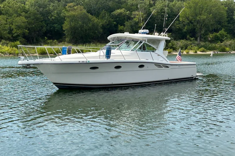 Slide: The Image of 2002 Tiara Yachts 3500 Open boat on calm water with lush green background. - 4