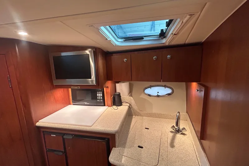 Slide: The Image of Interior of 2002 Tiara Yachts 3500 Open, featuring a compact kitchen with microwave and sink. - 33