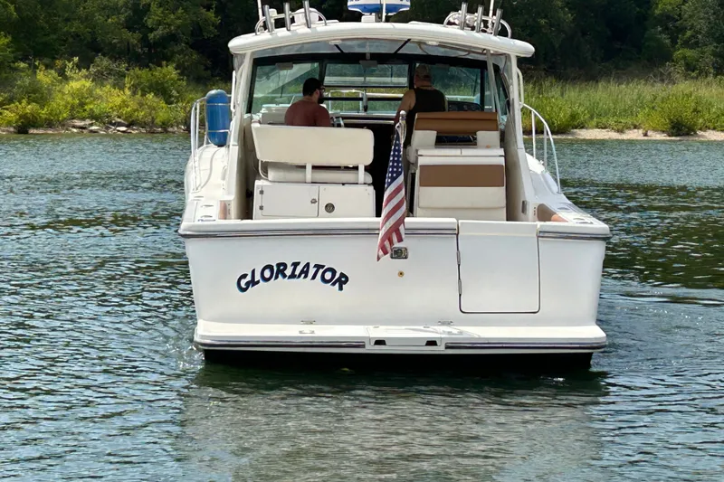 Slide: The Image of 2002 Tiara Yachts 3500 Open boat named "Gloriator" on a serene lake. - 8
