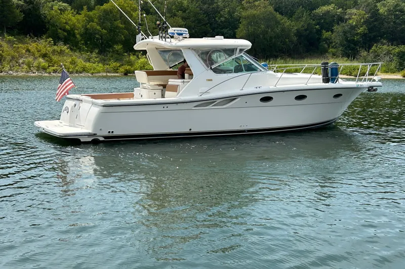 Slide: The Image of 2002 Tiara Yachts 3500 Open cruising on a serene lake with lush greenery. - 1