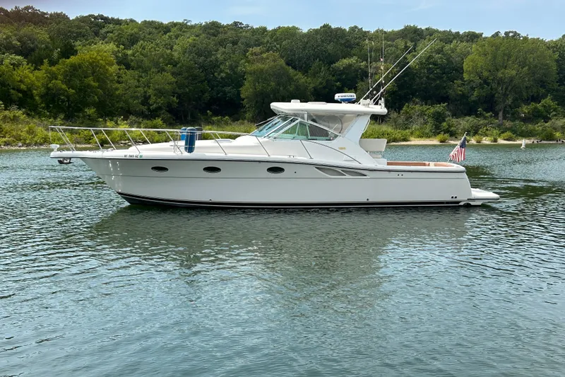 Slide: The Image of 2002 Tiara Yachts 3500 Open boat on calm water with lush green shoreline. - 46