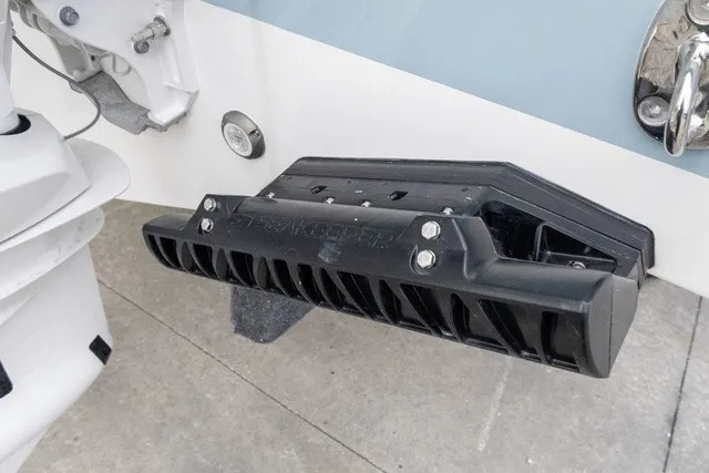 Slide: The Image of Close-up of a black trim system on a boat's stern, with part of the engine visible. - 30