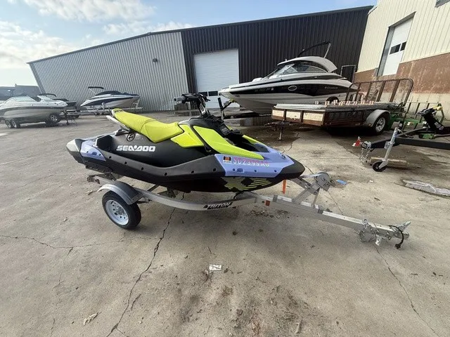 Slide: The Image of A 2024 Sea-Doo Spark Trixx for 3 on a trailer, surrounded by other boats. - 5