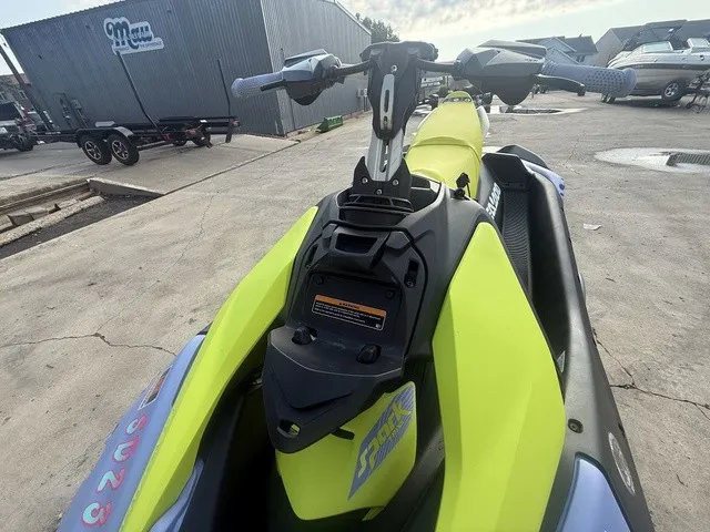 Slide: The Image of A yellow Sea-Doo Spark Trixx for 3 people is on a concrete surface. Handlebars and seat are visible. - 12