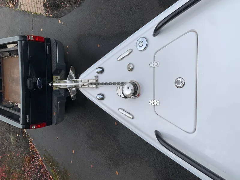 Slide: The Image of Bow of a white boat with anchor chain, next to a black vehicle. - 17