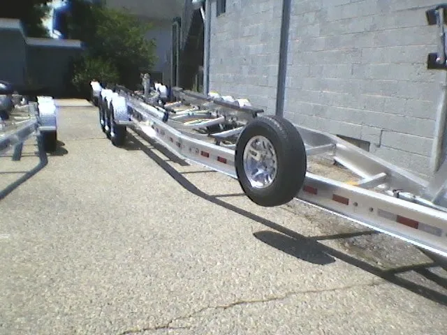 Slide: The Image of A boat trailer with a spare tire, parked on a concrete surface next to a building. - 26