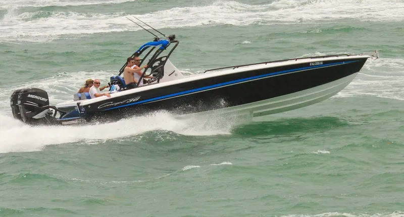 Slide: The Image of A black and white motorboat speeds through choppy waters. Several people are on board. - 25