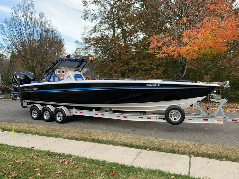Slide: The Image of A black 36-foot boat on a trailer, surrounded by autumn trees. - 24