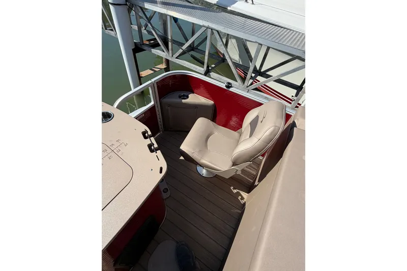 Slide: The Image of 2022 Bennington L 25 FISHING SSAPG boat interior with beige seating and red accents. - 5