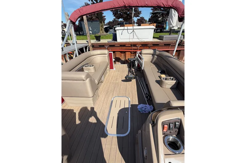 Slide: The Image of 2022 Bennington L 25 FISHING SSAPG pontoon boat interior with beige seating and red canopy. - 6