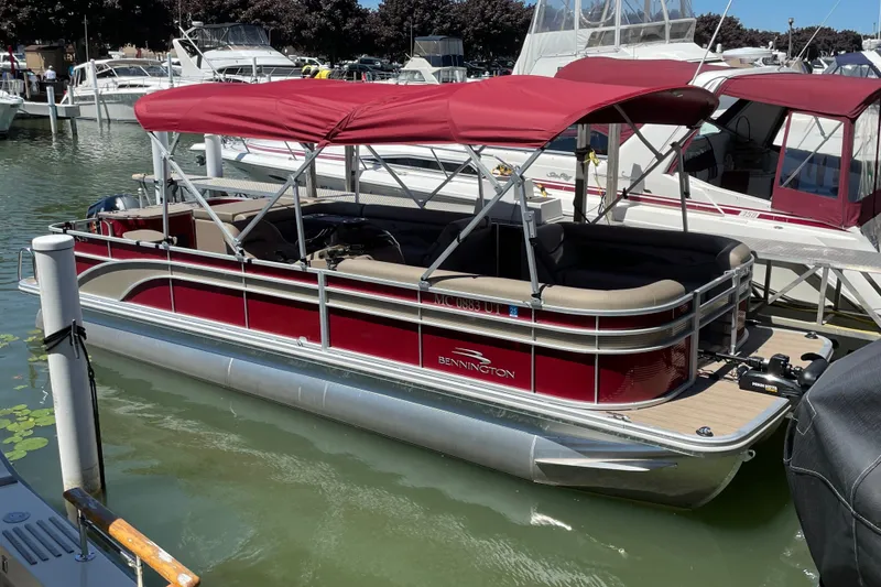 The Image of 2022 Bennington L 25 FISHING SSAPG pontoon boat docked with red canopy. - 0