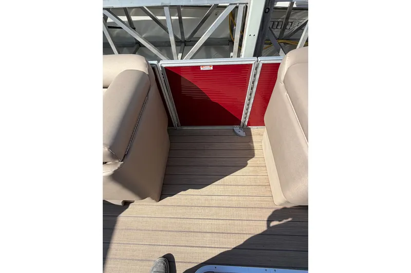 Slide: The Image of 2022 Bennington L 25 FISHING SSAPG boat interior with beige seating and red panel. - 7