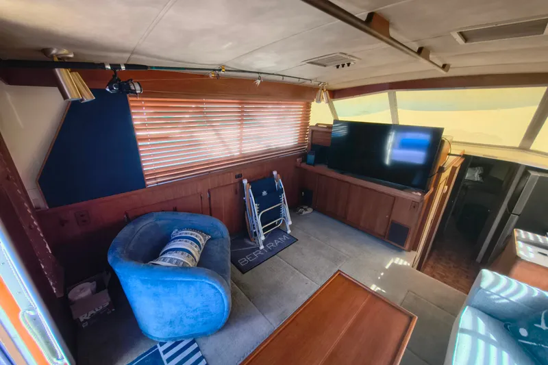 Slide: The Image of Interior of a 1985 Bertram 42 Convertible yacht with cozy seating and large TV. - 15