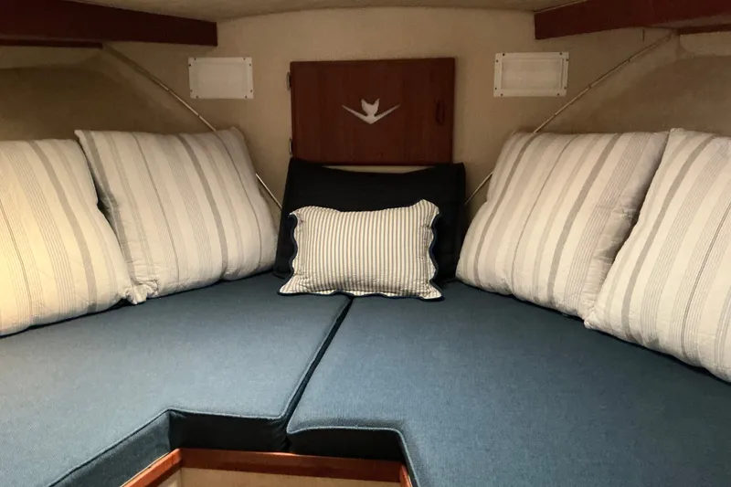 Slide: The Image of Cozy cabin interior of 1985 Bertram 42 Convertible with striped pillows and blue cushions. - 11