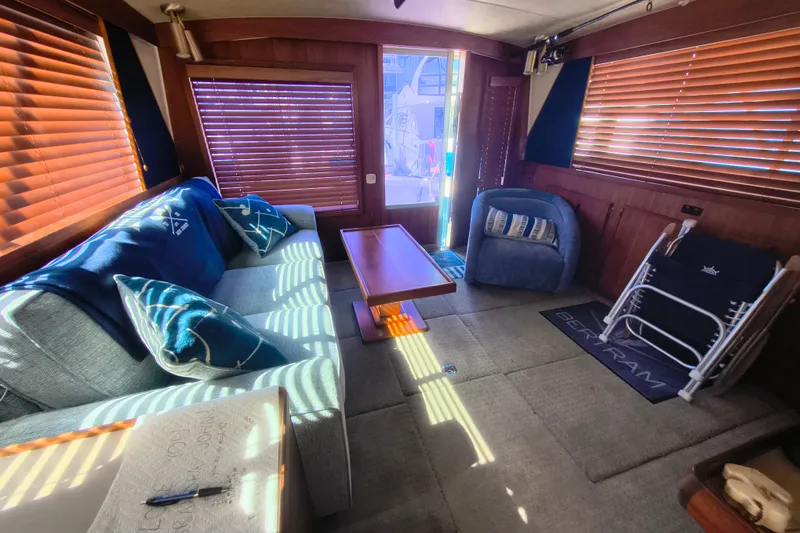 Slide: The Image of Interior of a 1985 Bertram 42 Convertible yacht with cozy seating and wooden blinds. - 16