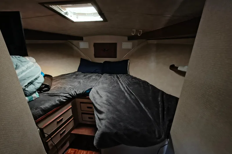 Slide: The Image of Cozy cabin interior of 1985 Bertram 42 Convertible yacht with bed and storage. - 21
