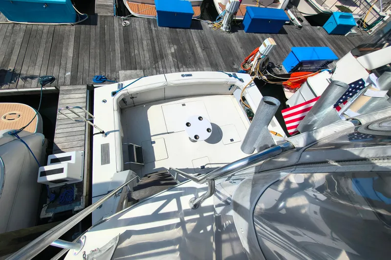 Slide: The Image of 1985 Bertram 42 Convertible yacht docked, view of deck and marina surroundings. - 12