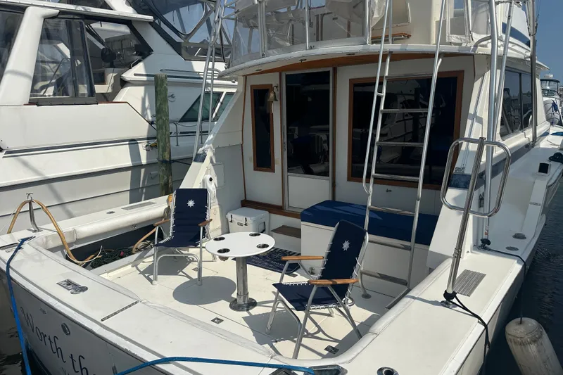 Slide: The Image of 1985 Bertram 42 Convertible yacht with seating area and table on deck. - 1