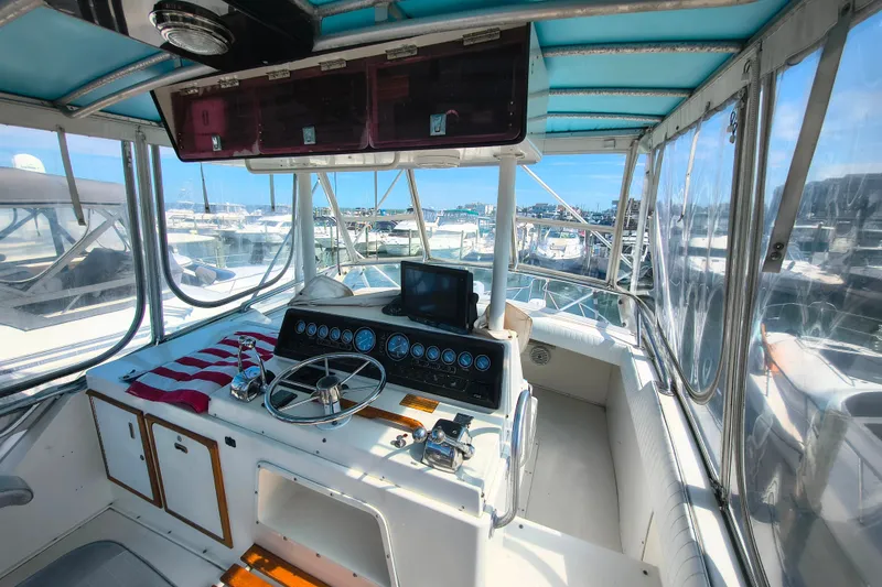 Slide: The Image of Cockpit of a 1985 Bertram 42 Convertible yacht with marina view. - 5