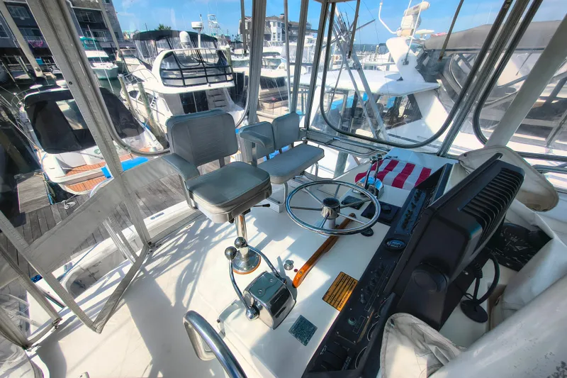 Slide: The Image of Cockpit of a 1985 Bertram 42 Convertible yacht, featuring steering wheel and controls. - 8