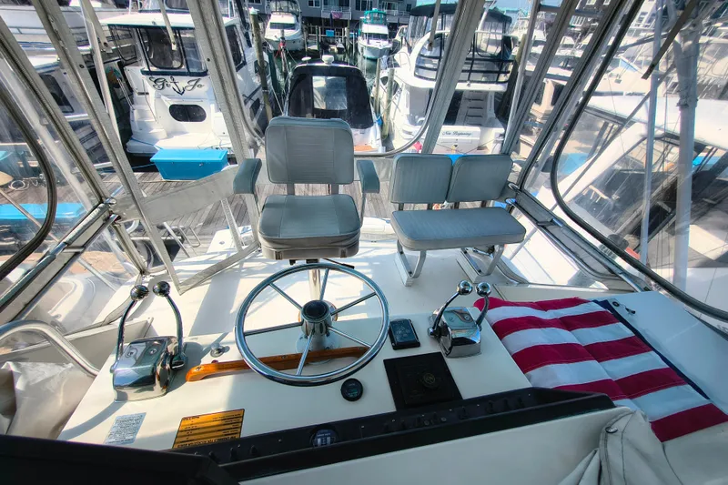 Slide: The Image of Cockpit view of a 1985 Bertram 42 Convertible yacht at a marina. - 10