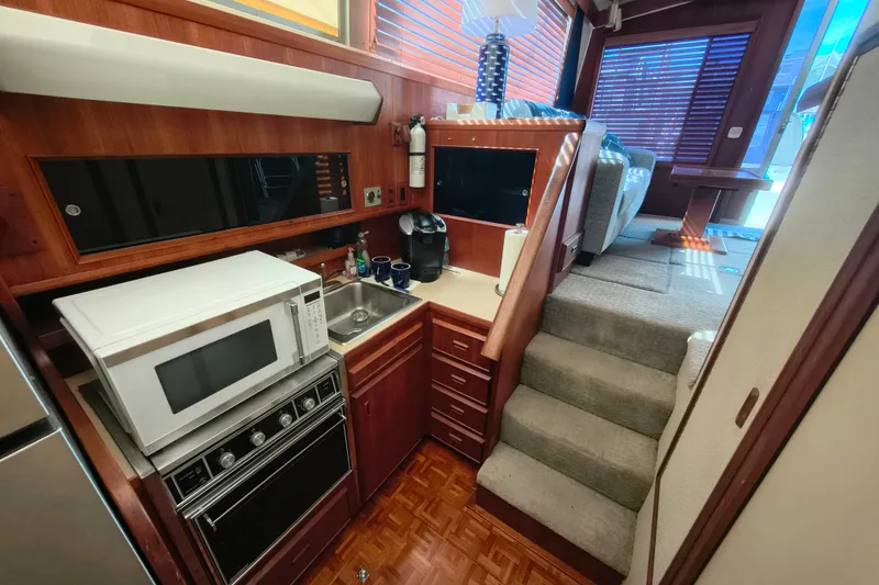 Slide: The Image of 1985 Bertram 42 Convertible yacht interior with kitchen, microwave, and stairs leading to seating area. - 18