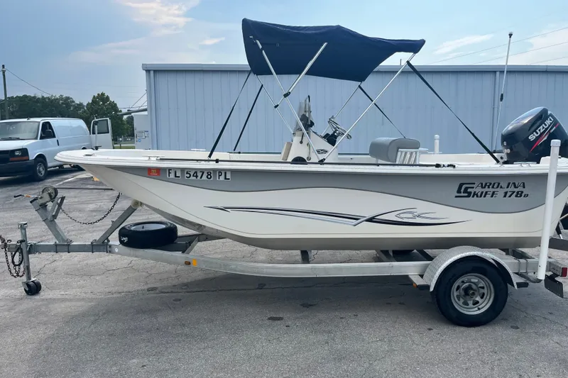 The Image of 2013 Carolina Skiff 178 DLV boat on trailer with Suzuki outboard motor. - 1