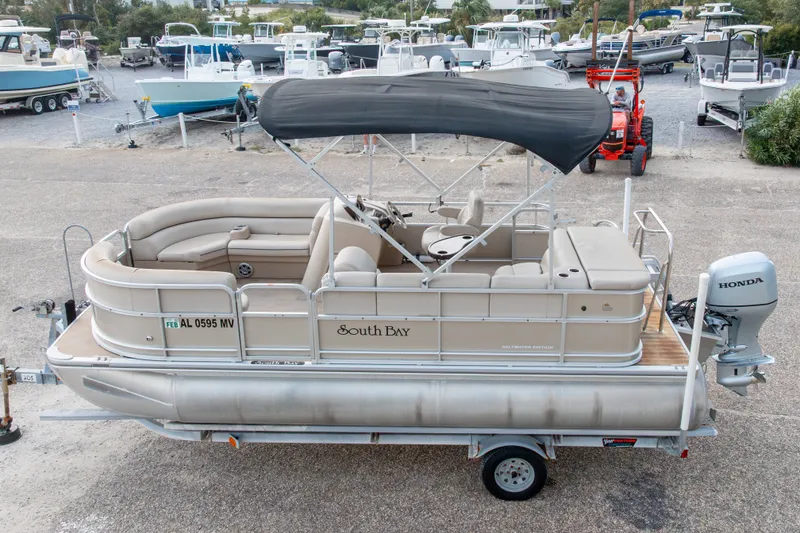 Slide: The Image of 2016 South Bay 5220CR pontoon boat with canopy on trailer, parked in marina. - 3