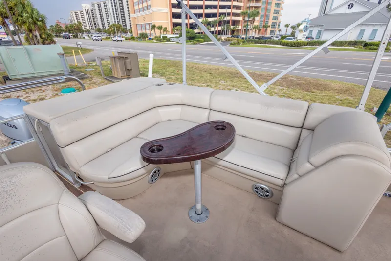 Slide: The Image of 2016 South Bay 5220CR pontoon boat interior with beige seating and a small table. - 19