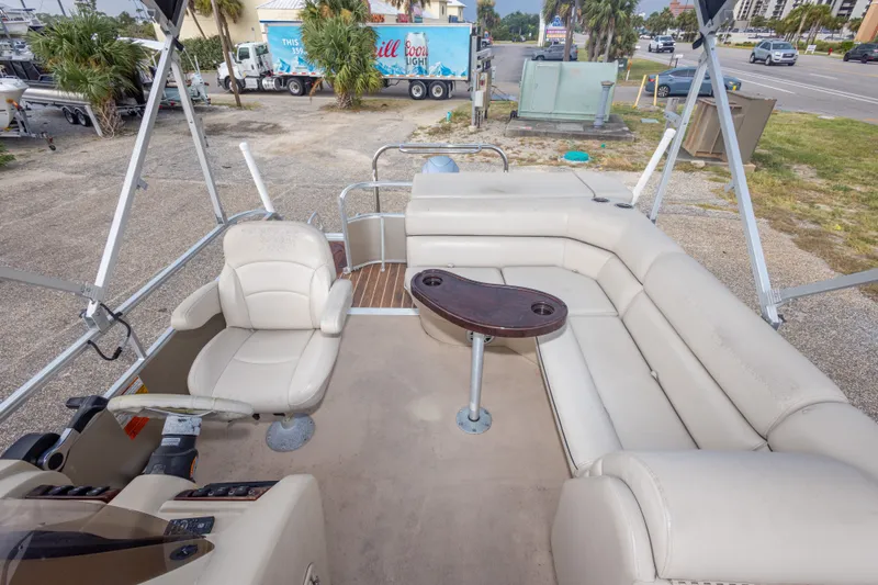 Slide: The Image of 2016 South Bay 5220CR pontoon boat interior with beige seating and a central table. - 20