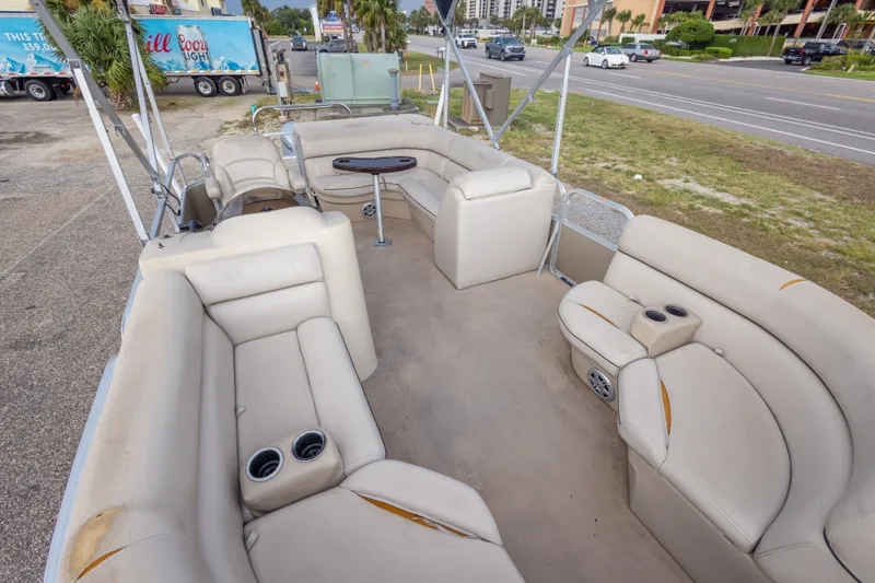 Slide: The Image of 2016 South Bay 5220CR pontoon boat with spacious seating and cup holders, parked roadside. - 24
