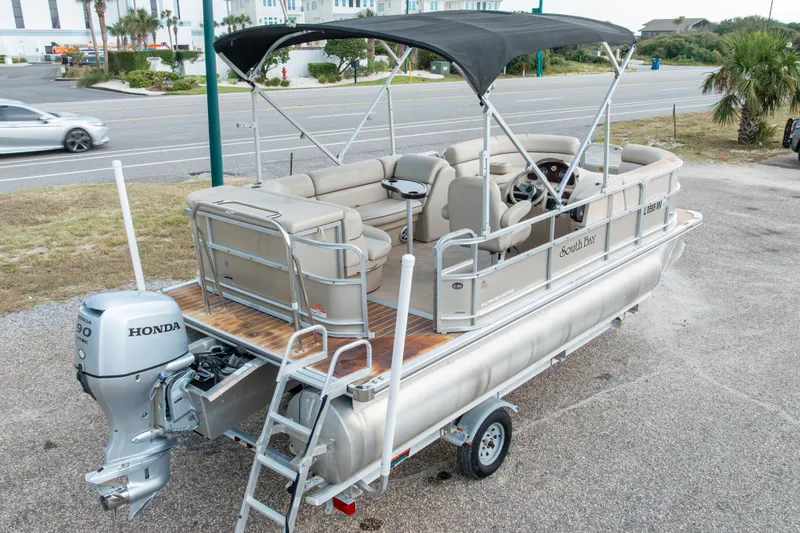 Slide: The Image of 2016 South Bay 5220CR pontoon boat with Honda outboard motor, parked on a trailer. - 42
